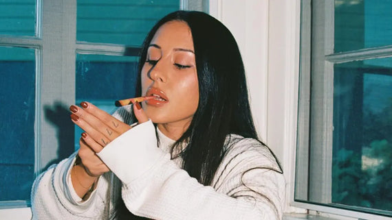 Best rolling cones being lit by a woman indoors, holding a striped cone with bold style and calm focus