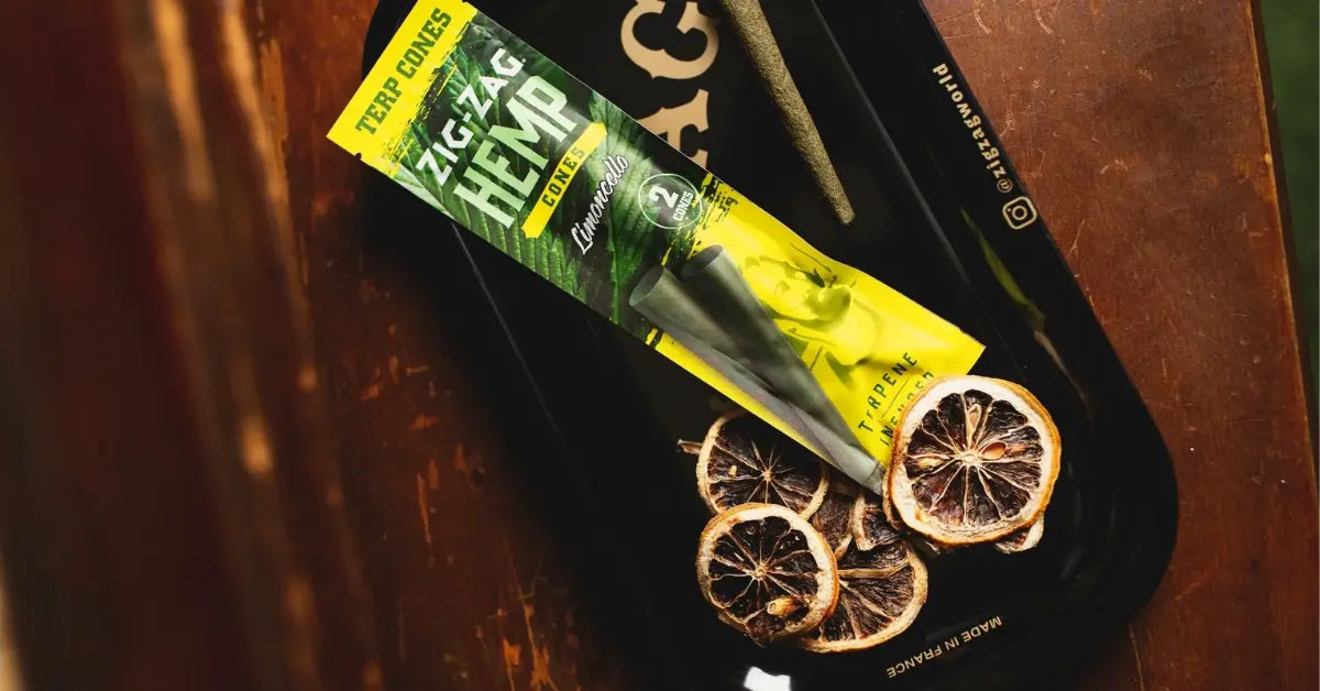 Terpene hemp cones in Zig-Zag Limoncello packaging with tray and dried citrus garnish for flavor emphasis.