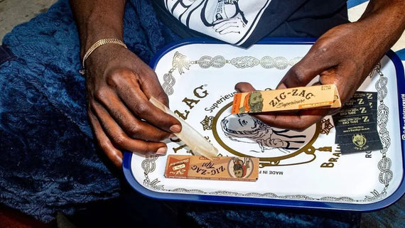 Thinnest rolling papers being prepared on a decorative tray with classic Zig-Zag packaging in hand