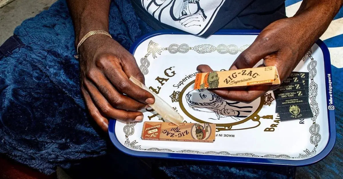 Thinnest rolling papers being prepared on a decorative tray with classic Zig-Zag packaging in hand
