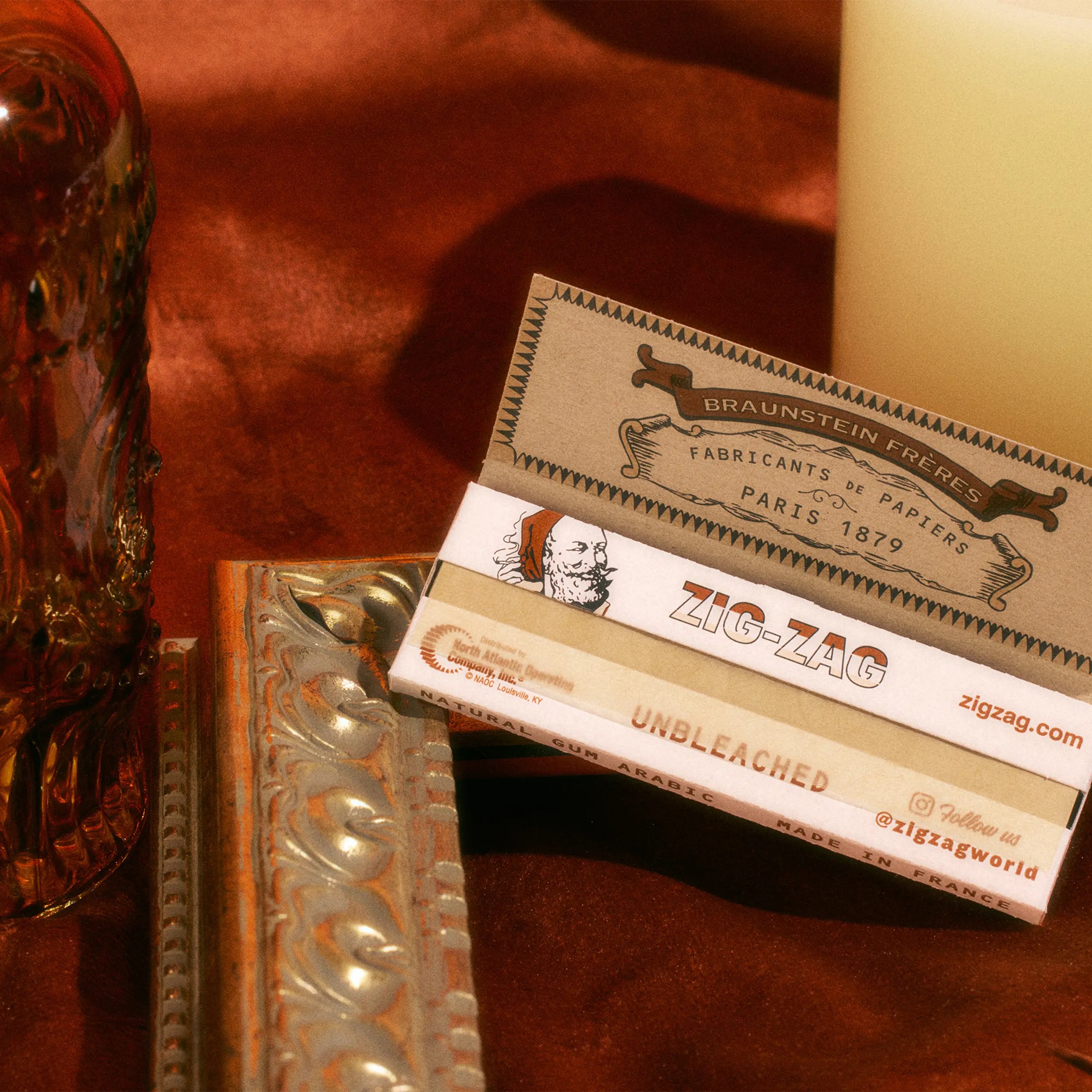 Zig-Zag unbleached rolling papers opened to reveal detailed branding, displayed on a warm decorative surface.