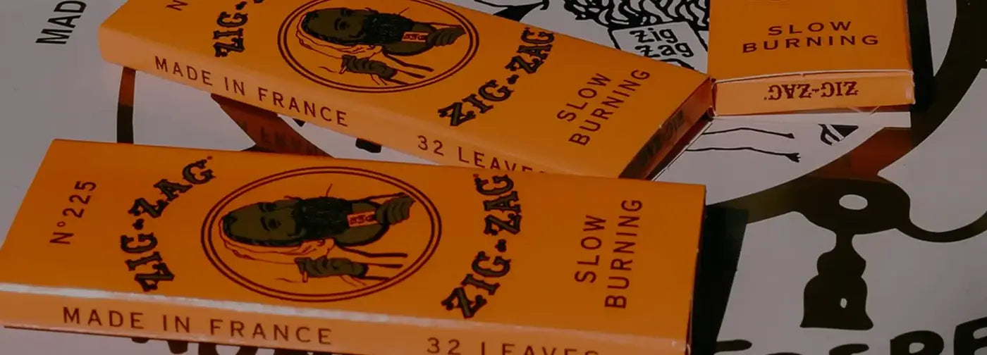 Close-up of classic orange Zig-Zag rolling paper packs labeled as slow burning &  made in France