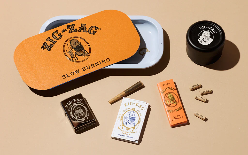 Modern smoking accessories from Zig-Zag including rolling tray, grinder, papers, and tips displayed on neutral background.