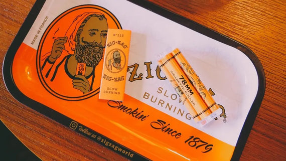 Top-rated smoking accessories including Zig-Zag slow burning papers and a 78mm roller on a branded orange tray
