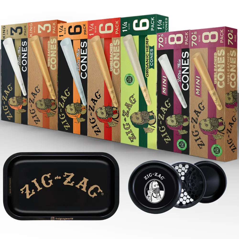 Hemp cones in assorted Zig-Zag packaging alongside a black Zig-Zag rolling tray and herb grinder on a white background.