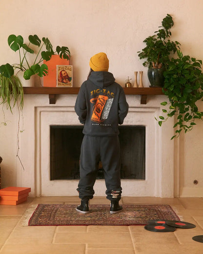 Black Zig-Zag sweatpants with embroidered ankle design, paired with a matching hoodie and yellow beanie.