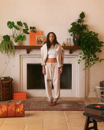 Zig-Zag branded cream sweatpants paired with a cropped top and matching sweatshirt draped over shoulders.